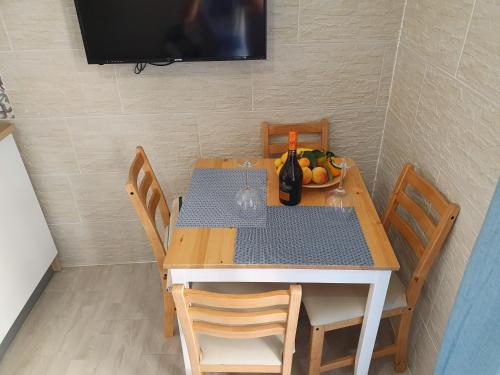 a table with a bottle of wine and a bowl of fruit at Posidonia in Porticello
