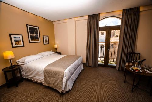 a hotel room with a bed and a large window at ATOJJA CHUCUITO HOTEL in Puno