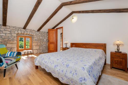 um quarto com uma cama king-size e uma cadeira em Vacation house Ana em Nedeščina