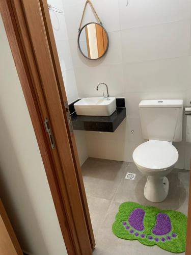 a bathroom with a toilet and a sink and a rug at Maraca Beach in Porto De Galinhas