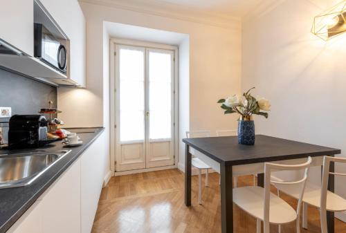 a kitchen with a table with a vase of flowers at Milan Royal Suites - Centro in Milan