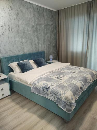 a bedroom with a large bed with a blue headboard at Simona Apartament Iulius Mall in Iaşi
