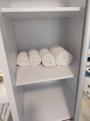 tres rollos de toallas en un estante en un armario en Simona Apartament Iulius Mall, en Iaşi