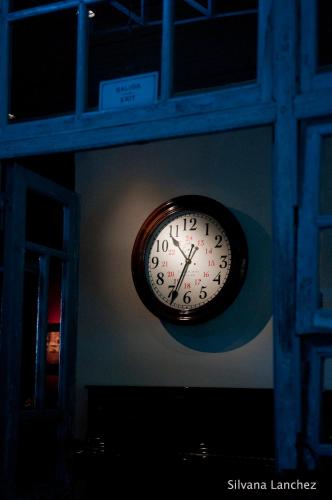 a clock hanging on the side of a wall at La Alondra, Casa de huéspedes in Corrientes