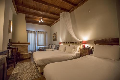 a hotel room with two beds and a couch at Archontiko Zakoni in Neochori