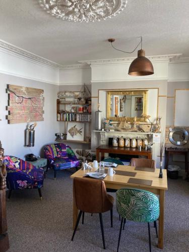 a living room with a table and a couch at Kelston Guest House in Weymouth