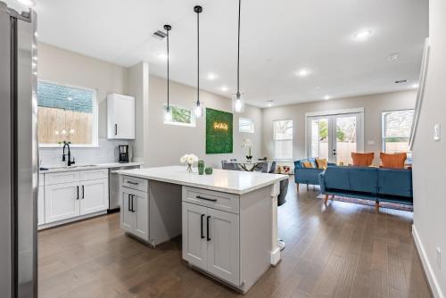 a kitchen with white cabinets and a living room at 3 Bedroom and 3 bath in Houston