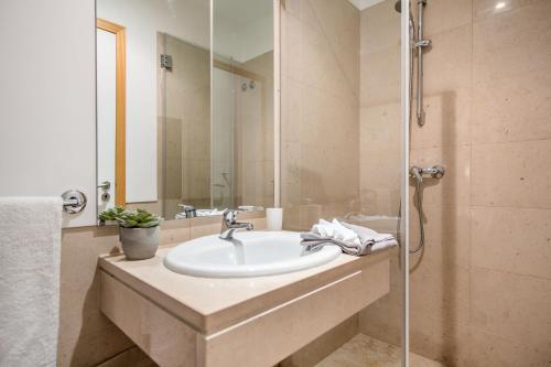 y baño con lavabo y ducha. en Appartement Luxueux dans un site Exceptionnelle Vilamoura, en Vilamoura