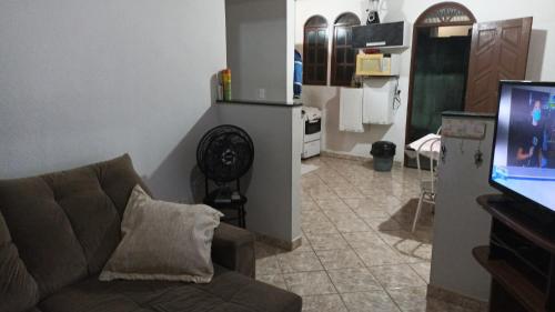 a living room with a couch and a kitchen at Casa de praia P Grande in Fundão