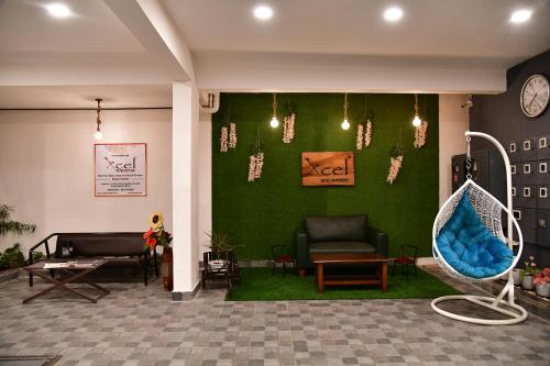 a waiting room with a green wall with a swing at Xcel Luxury Hotel Apartments-Home Living Redefined in Mysore