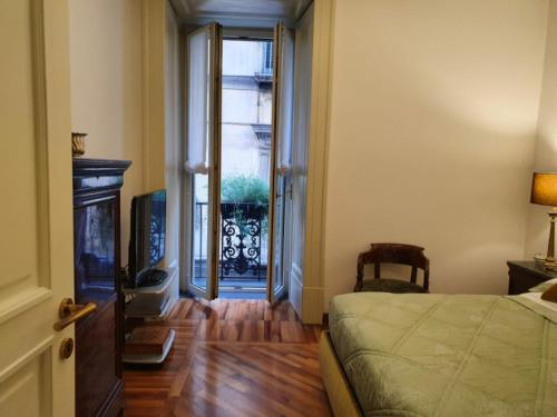 a bedroom with a bed and a door to a balcony at L'Arnia in Naples