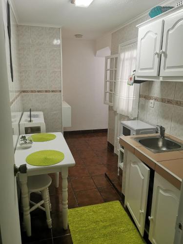 a small kitchen with a sink and a table at Alojamento Bela Vista in Lajes do Pico