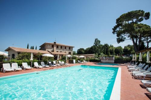 a pool with lounge chairs and a villa in the background at Borgo di Pomaia in Pomaia