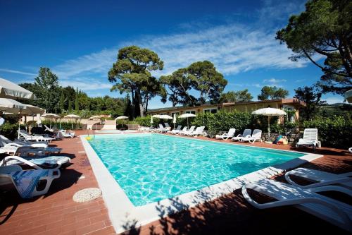 a large swimming pool with chairs and umbrellas at Borgo di Pomaia in Pomaia