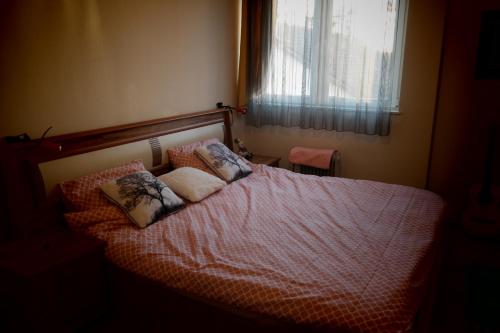 ein Schlafzimmer mit einem Bett mit zwei Kissen darauf in der Unterkunft E-19 Home - Tradition meets tourism in Prizren