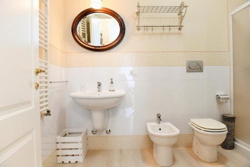 a bathroom with a sink and a toilet and a mirror at Dimora del Castellano GREEN HOUSE in Gioia del Colle
