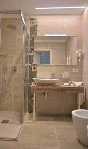 a bathroom with a sink and a glass shower at Amsterdam Suite Hotel & SPA in Rimini