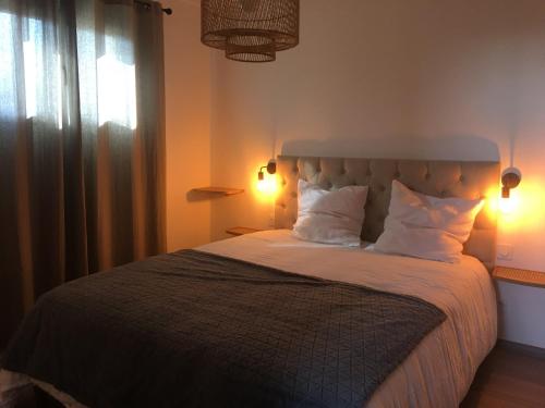 Un dormitorio con una cama con almohadas blancas y una ventana en Gîte du Soleil Levant - Drôme des collines, en Bren