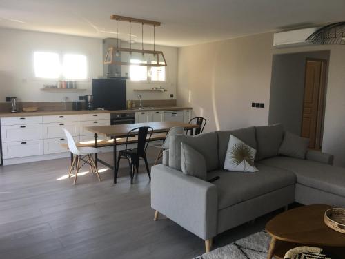 a living room with a couch and a table at Gîte du Soleil Levant - Drôme des collines in Bren
