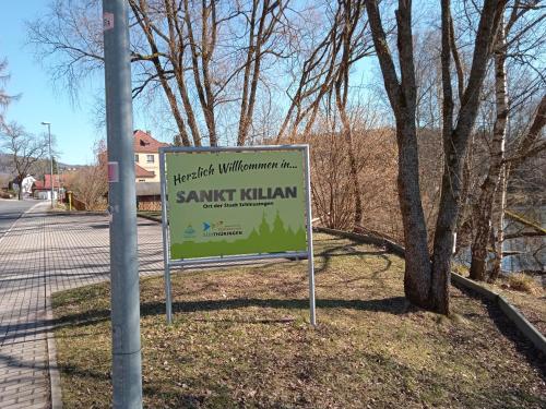 a sign in the grass next to a street at Hotel & Restaurant Zum Adlersberg in Schleusingen