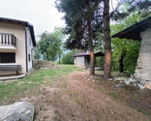 a yard with a bench next to a building at Secou d'Fredu - la casa nel bosco in San Damiano Macra