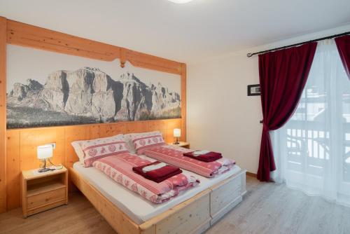 una camera con un letto con due cuscini sopra di B&B Agriturismo Cèsa Ciasates a Canazei