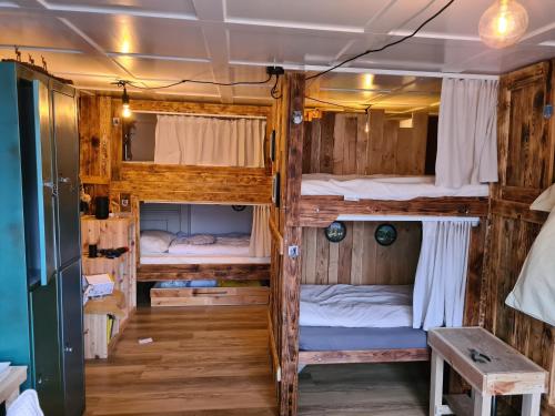 a room with three bunk beds and a table at Backpacker Bären in Urnäsch