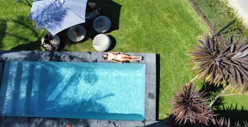an overhead view of a person laying on the grass next to a swimming pool at Sunshowers Plett in Plettenberg Bay