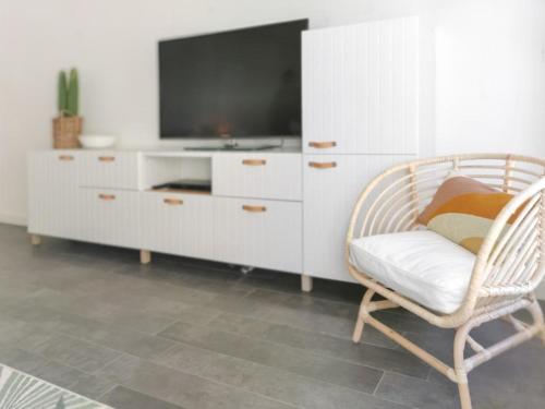 uma sala de estar com uma televisão e uma cadeira em LE SEA SIDE - Ultra centre - Terrasse vue Mer - 4 personnes em Cassis