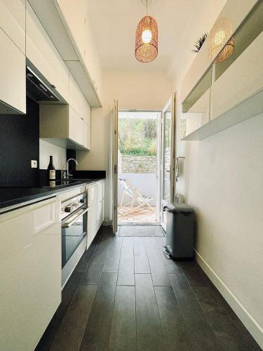 une cuisine avec des placards blancs et une porte donnant sur une terrasse. dans l'établissement LE SEA SIDE - Ultra centre - Terrasse vue Mer - 4 personnes, à Cassis