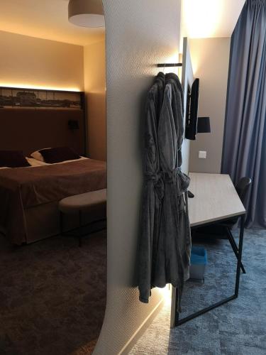 a room with a bed and a coat hanging on a wall at SpaHotel Hamina in Hamina