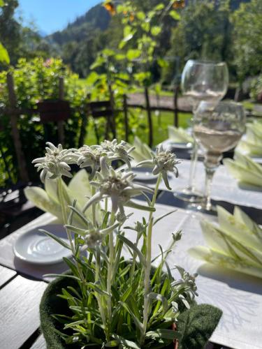 a table with plates and glasses and a plant on it at Hotel-Gasthof Der Wiesengrund in Bad Hindelang