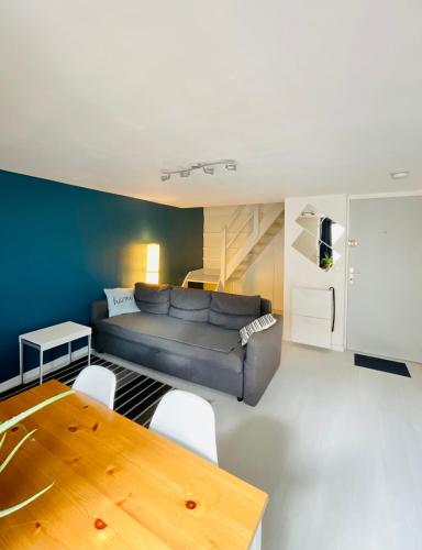 ein Wohnzimmer mit einem Sofa und einem Tisch in der Unterkunft Dupleix Centre Ville Montlhéry Parking 30min Paris in Montlhéry