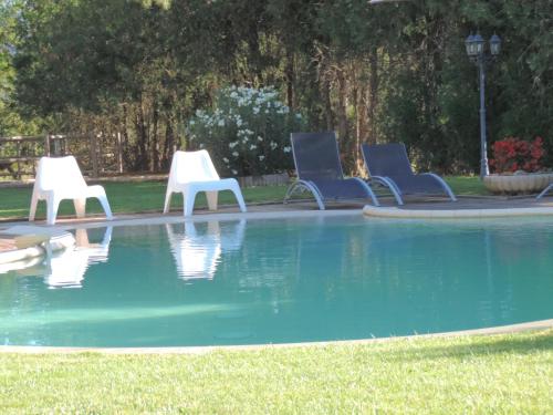 a group of chairs sitting next to a swimming pool at Mas de la Sauline in La Roque-dʼAnthéron