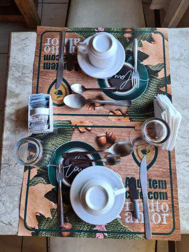 een tafel met borden en keukengerei erop bij Pousada Centro Class in Búzios