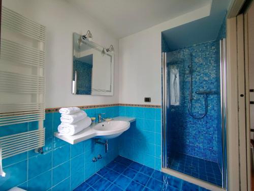 y baño azul con lavabo y ducha. en B&B Villa Letizia en San Vito Rimini