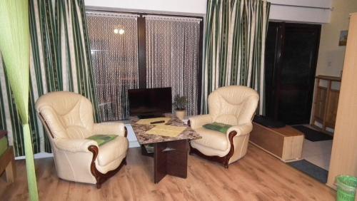 ein Wohnzimmer mit 2 Stühlen und einem Tisch in der Unterkunft Ferienwohnung Weingart Quedlinburg in Quedlinburg