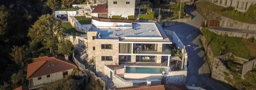 an aerial view of a large house with a swimming pool at Quinta da Nascente in Soutelo