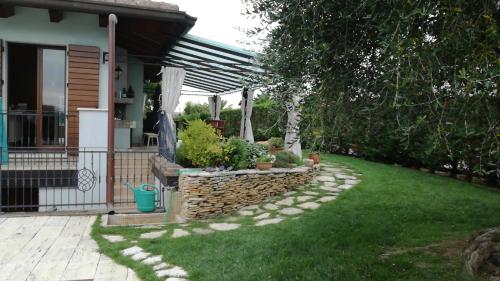 a garden with a stone wall and a fence at B&B Villa Letizia in San Vito Rimini