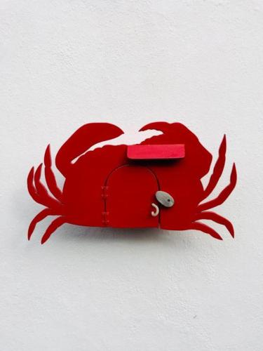 un porte-monnaie rouge suspendu à un mur dans l'établissement Le crabe rouge, à Groix