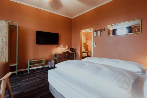 a hotel room with a bed and a television at Hotel Hafnia in Tórshavn