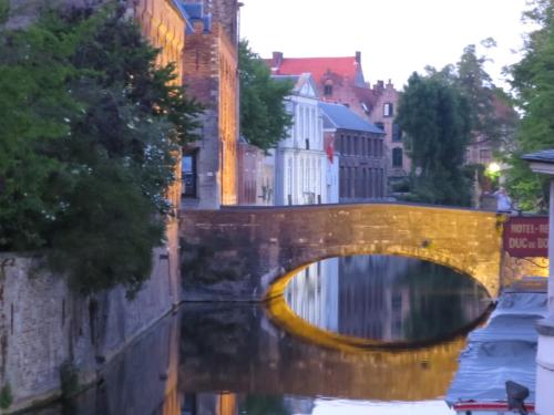 a bridge over a river in a city at Hotel Alegria in Bruges