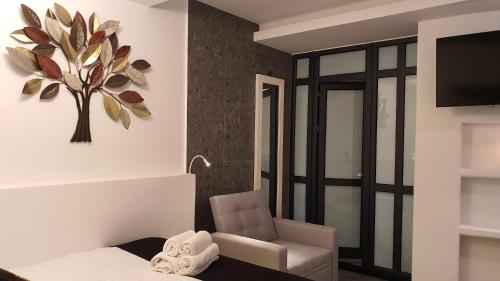a room with a chair and a plant on the wall at Mykonos Double Luxury Mini Suites-With External Hot spa Adults only in Ano Mera