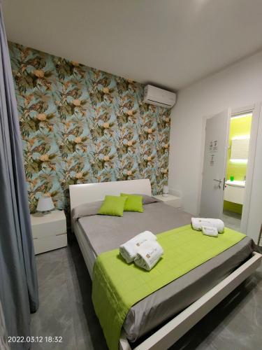 a bedroom with a bed with a green blanket at Bed Nonnonino in Porto Cesareo