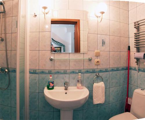 a bathroom with a sink and a mirror and a toilet at Willa Epoka in Międzyzdroje