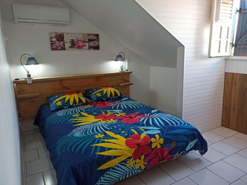 een slaapkamer met een bed met een kleurrijk dekbed bij Ti Cozy in Baie-Mahault