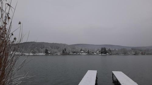 a lake with two benches in the water at Onix - Orfű Apartman in Orfű