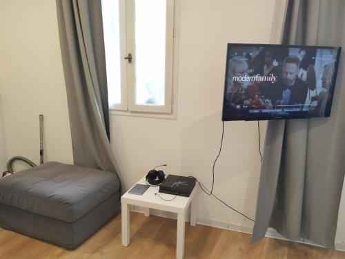 un salon avec une télévision, un canapé et une table dans l'établissement Studio Neuf climatisé tout équipé #2, à Toulon