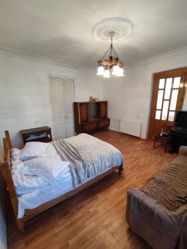 um quarto com uma cama grande e um lustre em Vintage Door Tbilisi em Tbilisi