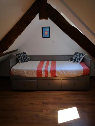 - un lit au milieu d'un grenier dans l'établissement Studio vacances proche plages, à Neufchâtel-Hardelot